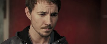 Movie still from “The Disappearance of Alice Creed” (2009), directed by J Blakeson – A man's face with a red background; Close Up shot, High angle