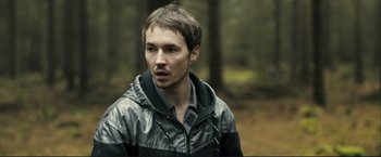 Movie still from “The Disappearance of Alice Creed” (2009), directed by J Blakeson – A young man in a black and silver jacket; Close Up shot, Over the shoulder angle