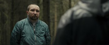 Movie still from “The Disappearance of Alice Creed” (2009), directed by J Blakeson – A man standing in front of another man in the woods; Close Up shot, Over the shoulder angle