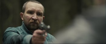 Movie still from “The Disappearance of Alice Creed” (2009), directed by J Blakeson – A man with a beard holding a gun in his hand; Close Up shot, Over the shoulder angle