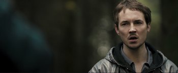 Movie still from “The Disappearance of Alice Creed” (2009), directed by J Blakeson – A man in a silver jacket is looking to his left; Close Up shot, Over the shoulder angle