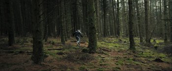 Movie still from “The Disappearance of Alice Creed” (2009), directed by J Blakeson – A person is running through the woods on a dirt path; Extreme Wide shot, Low angle