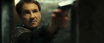 Movie still from “The Disappearance of Alice Creed” (2009), directed by J Blakeson – A person holding a gun in his hand; Close Up shot, Over the shoulder angle