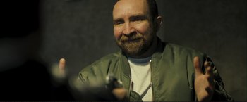 Movie still from “The Disappearance of Alice Creed” (2009), directed by J Blakeson – A man with a goatee holding a gun in his hand; Close Up shot, Over the shoulder angle