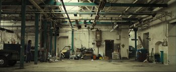 Movie still from “The Disappearance of Alice Creed” (2009), directed by J Blakeson – An industrial building with a lot of trash on the floor; Extreme Wide shot, High angle