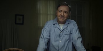 Movie still from “House of Cards” (2013), created by Beau Willimon – A man in a blue shirt is smiling for the camera; Close Up shot, Low angle