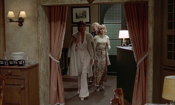 Movie still from “The Discreet Charm of the Bourgeoisie” (1972), directed by Luis Buñuel – A group of women walking through a doorway; Wide shot, Low angle
