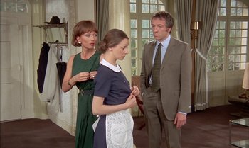 Movie still from “The Discreet Charm of the Bourgeoisie” (1972), directed by Luis Buñuel – Two women and a man in a room with a mirror; Medium shot, Over the shoulder angle