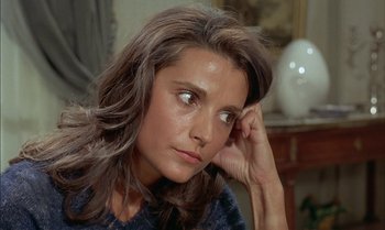 Movie still from “The Discreet Charm of the Bourgeoisie” (1972), directed by Luis Buñuel – A person sitting with her hand on her head; Close Up shot, High angle