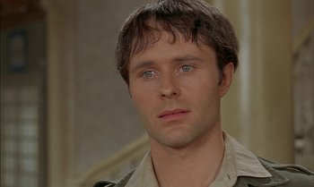 Movie still from “The Discreet Charm of the Bourgeoisie” (1972), directed by Luis Buñuel – A person wearing a jacket; Close Up shot, Over the shoulder angle