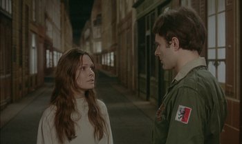 Movie still from “The Discreet Charm of the Bourgeoisie” (1972), directed by Luis Buñuel – A man and a woman standing next to each other on a street; Medium shot, High angle