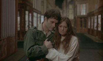 Movie still from “The Discreet Charm of the Bourgeoisie” (1972), directed by Luis Buñuel – A man and a woman standing next to each other on a street; Medium shot, High angle