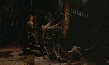 Movie still from “The Discreet Charm of the Bourgeoisie” (1972), directed by Luis Buñuel – A man walking down stairs next to a fire hydrant; Wide shot, High angle