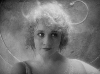 Movie still from “The Docks of New York” (1928), directed by Josef von Sternberg – An old black and white photo of a woman with curly hair; Close Up shot, High angle