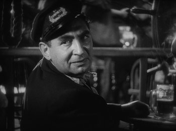 Movie still from “The Docks of New York” (1928), directed by Josef von Sternberg – A man wearing a hat sitting at a table in a restaurant; Close Up shot, Low angle