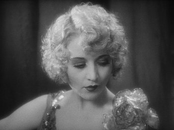 Movie still from “The Docks of New York” (1928), directed by Josef von Sternberg – An old photo of a woman with a flower in her hand; Close Up shot, High angle