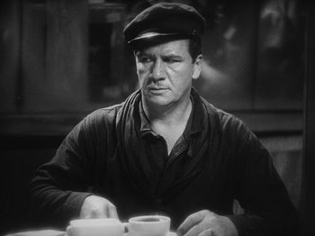Movie still from “The Docks of New York” (1928), directed by Josef von Sternberg – A man sitting at a table with a roll of toilet paper in front of him; Medium shot, Low angle