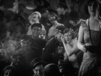 Movie still from “The Docks of New York” (1928), directed by Josef von Sternberg – A group of people sitting and standing in a room; Medium shot, Low angle