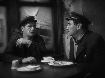Movie still from “The Docks of New York” (1928), directed by Josef von Sternberg – Two men sitting at a table with a cup of coffee; Medium shot, High angle