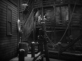 Movie still from “The Docks of New York” (1928), directed by Josef von Sternberg – A black - and - white photo of a boat in a dock; Extreme Wide shot, High angle