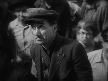 Movie still from “The Docks of New York” (1928), directed by Josef von Sternberg – An older man wearing a hat and a suit; Medium shot, High angle