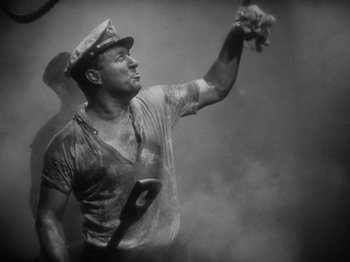 Movie still from “The Docks of New York” (1928), directed by Josef von Sternberg – Black and white photograph of a man holding a baseball glove; Medium shot, Low angle