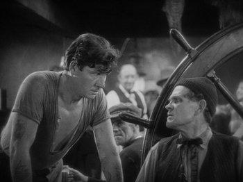 Movie still from “The Docks of New York” (1928), directed by Josef von Sternberg – A man talking to another man in front of a car; Medium shot, Low angle