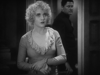Movie still from “The Docks of New York” (1928), directed by Josef von Sternberg – A woman in a dress standing in front of a mirror; Medium shot, Over the shoulder angle