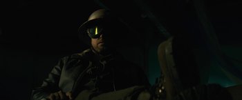 Movie still from “The Domestics” (2018), directed by Mike P. Nelson – A man wearing a helmet and goggles in the dark; Close Up shot, Low angle
