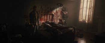 Movie still from “The Domestics” (2018), directed by Mike P. Nelson – A man standing next to a bed covered in blood; Wide shot, Over the shoulder angle