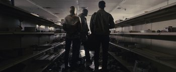 Movie still from “The Domestics” (2018), directed by Mike P. Nelson – A group of people standing in a room; Wide shot, Low angle