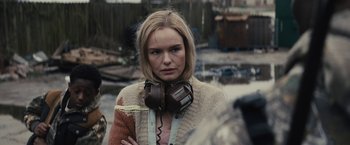 Movie still from “The Domestics” (2018), directed by Mike P. Nelson – A woman with headphones is posing for a picture; Close Up shot, Over the shoulder angle