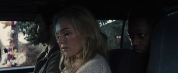 Movie still from “The Domestics” (2018), directed by Mike P. Nelson – A woman sitting in the back seat of a car; Close Up shot, Over the shoulder angle