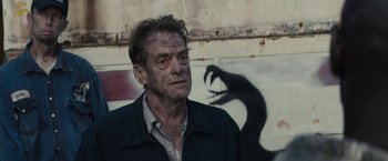 Movie still from “The Domestics” (2018), directed by Mike P. Nelson – A person wearing a jacket near a wall; Close Up shot, Over the shoulder angle