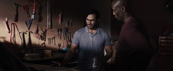 Movie still from “The Domestics” (2018), directed by Mike P. Nelson – A man standing next to another man holding a can of beer; Medium shot, Over the shoulder angle