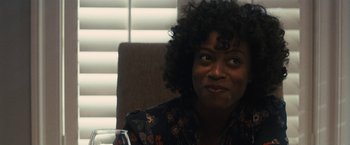 Movie still from “The Domestics” (2018), directed by Mike P. Nelson – A person sitting at a table with a glass of wine; Close Up shot, Over the shoulder angle