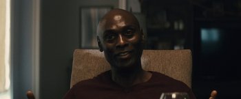 Movie still from “The Domestics” (2018), directed by Mike P. Nelson – A person sitting in a chair; Close Up shot, Over the shoulder angle