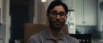 Movie still from “The Domestics” (2018), directed by Mike P. Nelson – A person sitting on a chair wearing glasses; Close Up shot, Over the shoulder angle