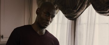 Movie still from “The Domestics” (2018), directed by Mike P. Nelson – A man with a bald head looking at the camera; Close Up shot, Over the shoulder angle