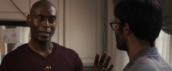 Movie still from “The Domestics” (2018), directed by Mike P. Nelson – Two men talking to each other in front of a wall; Close Up shot, Over the shoulder angle