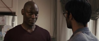 Movie still from “The Domestics” (2018), directed by Mike P. Nelson – Two men talking to each other in front of a wall; Close Up shot, Over the shoulder angle