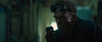 Movie still from “The Domestics” (2018), directed by Mike P. Nelson – An older man wearing goggles looking at a cell phone; Close Up shot, Low angle