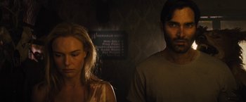 Movie still from “The Domestics” (2018), directed by Mike P. Nelson – A man and a woman standing next to each other in a room; Close Up shot, Over the shoulder angle