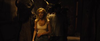 Movie still from “The Domestics” (2018), directed by Mike P. Nelson – A woman standing next to two men in a dark room; Medium shot, Over the shoulder angle