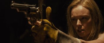 Movie still from “The Domestics” (2018), directed by Mike P. Nelson – A man with a beard is holding a gun; Close Up shot, Over the shoulder angle