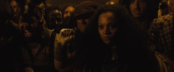 Movie still from “The Domestics” (2018), directed by Mike P. Nelson – A group of people standing in a dark room; Close Up shot, Over the shoulder angle