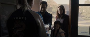 Movie still from “The Domestics” (2018), directed by Mike P. Nelson – A group of people standing next to each other near a window; Medium shot, Over the shoulder angle