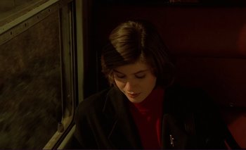 Movie still from “The Double Life of Véronique” (1991), directed by Krzysztof Kieslowski – A woman sitting on a train looking out the window; Close Up shot, High angle