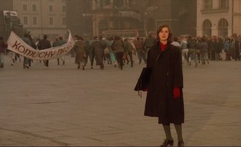 Movie still from “The Double Life of Véronique” (1991), directed by Krzysztof Kieslowski – A woman is standing in the middle of a crowd of people; Wide shot, High angle