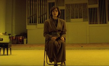 Movie still from “The Double Life of Véronique” (1991), directed by Krzysztof Kieslowski – A woman sitting on a chair in front of an organ; Wide shot, Low angle